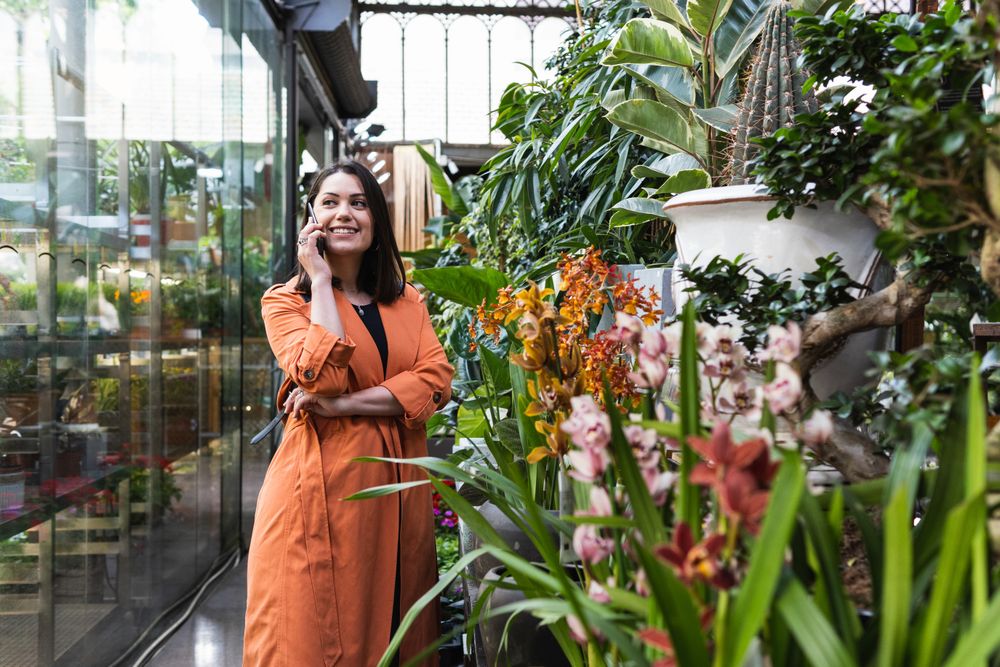 Content woman using the cellphone in garden center
