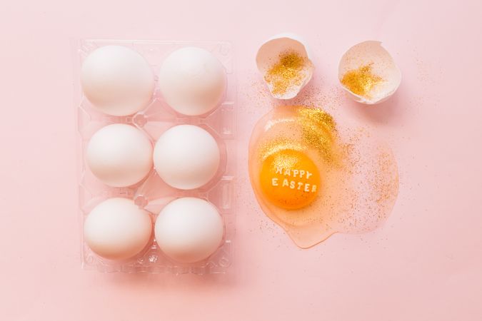 Easter eggs in box and broken egg on table