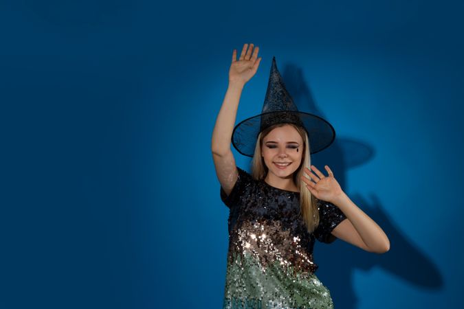 Concept of Halloween, young woman on blue background
