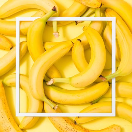 Bananas on yellow background with light frame