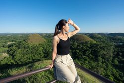 Happy woman standing on observation deck on hill