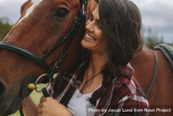 Close up of happy equestrian woman with a brown horse bD62y5