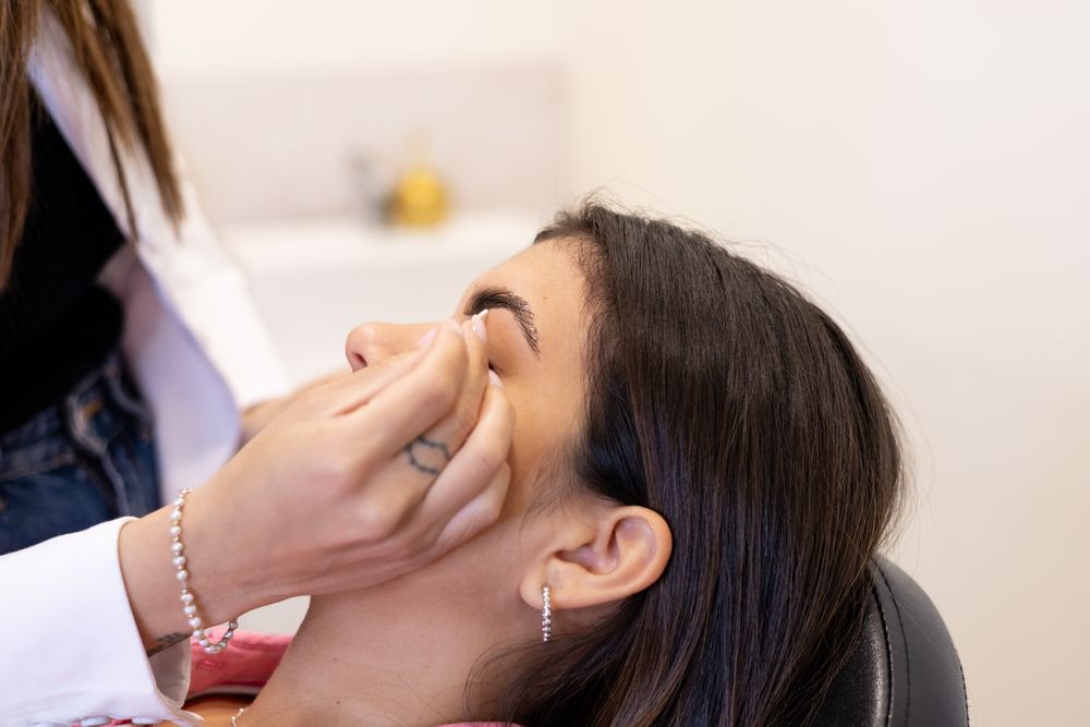 Beautician making eyebrow design and shading procedures