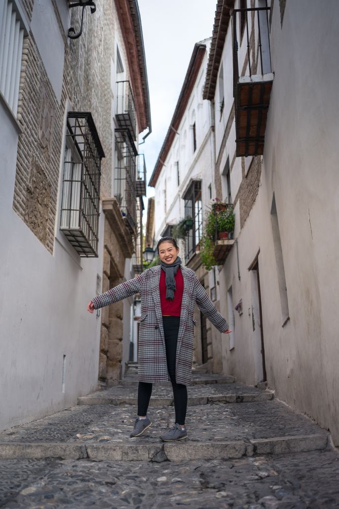 Joyful female tourist in casual wear amid city street