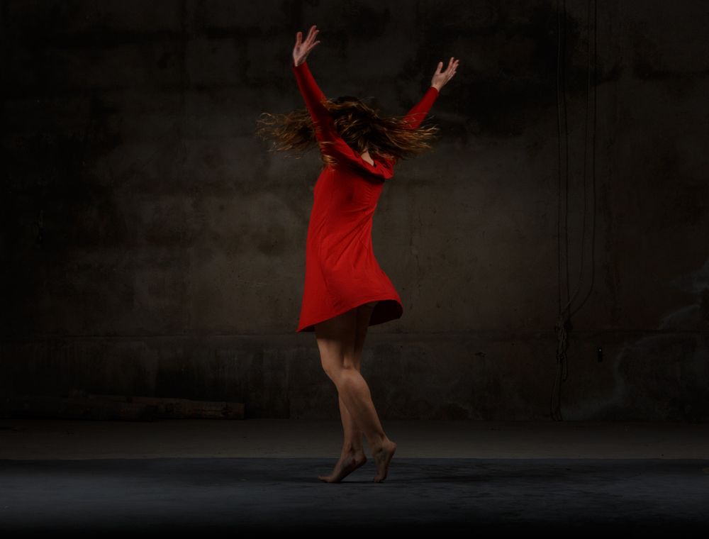 Young woman dancing in darkness