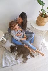 Young woman hugging barefoot son at home