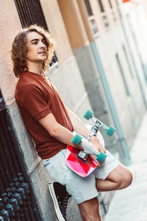 Man carrying longboard on the street