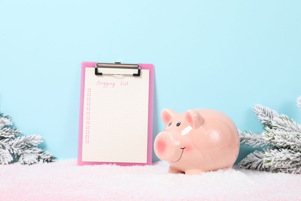 Piggy bank, folder with list and fir branches on blue background, space for text
