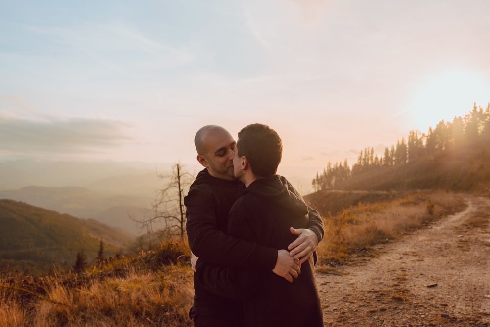 Men hugging and kissing in forest