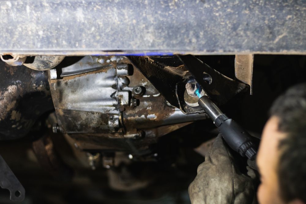 Anonymous repairman removing car details with torch during work in auto service