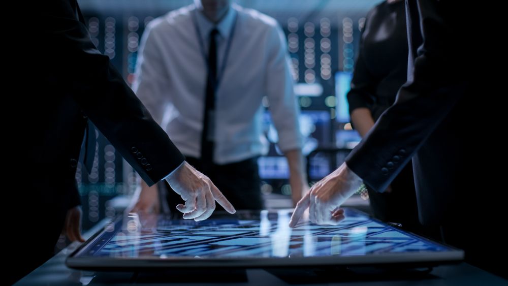 Corporate Managers Working at the Table in Monitoring Room.