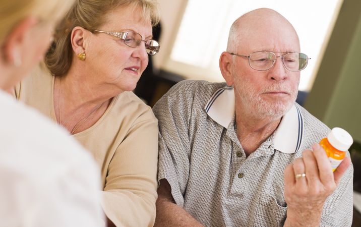 Doctor or Nurse Explaining Prescription Medicine to Older Couple