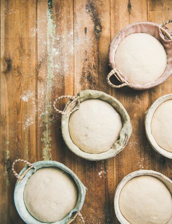 Top view of multiple baskets of bread dough