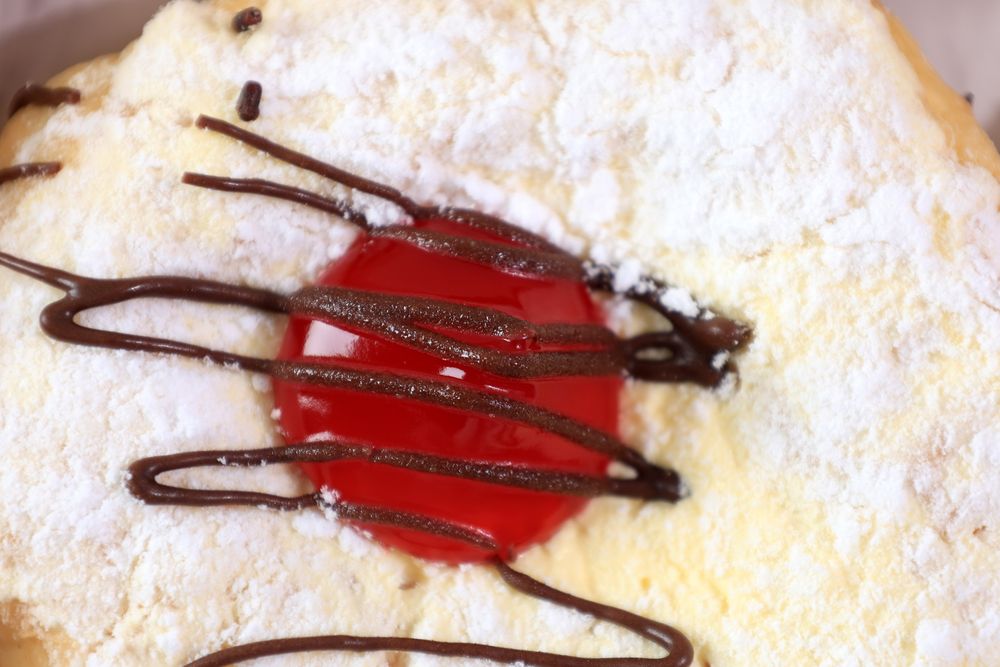 Donut with Powdered Sugar, Strawberry Jam, and Chocolate Sauce