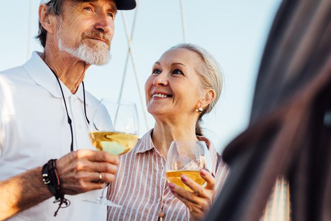 Happy older couple with wine on a boat