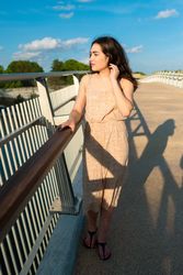 Peaceful woman in dress walking along rural bridge