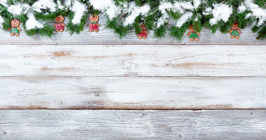 Snowy Christmas evergreen branches and cookies on vintage wooden planks