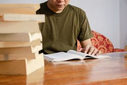 Asian young student study, reading and writing sit on sofa at living room