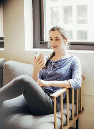 Woman using her phone while sitting on couch