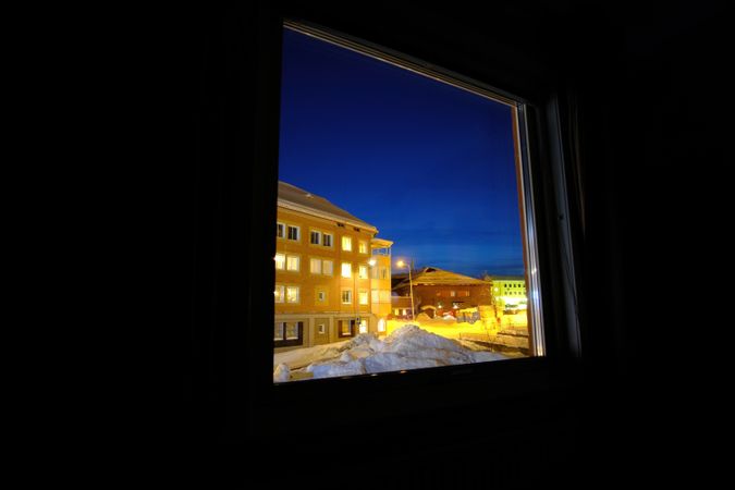 Illuminated street behind house window
