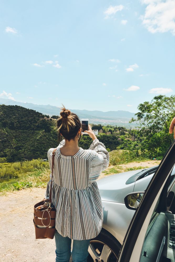 Group of friends enjoying a conversation outside the car.