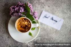 Top view of cup of espresso and lilacs on grey background with copy space 43293R