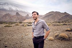 Positive young man resting in mountains in summer day