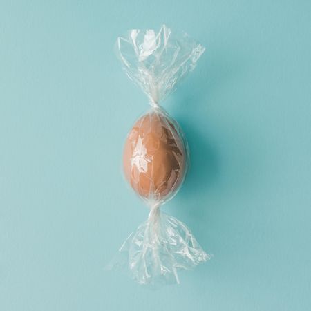 Egg wrapped like candy on bright blue background