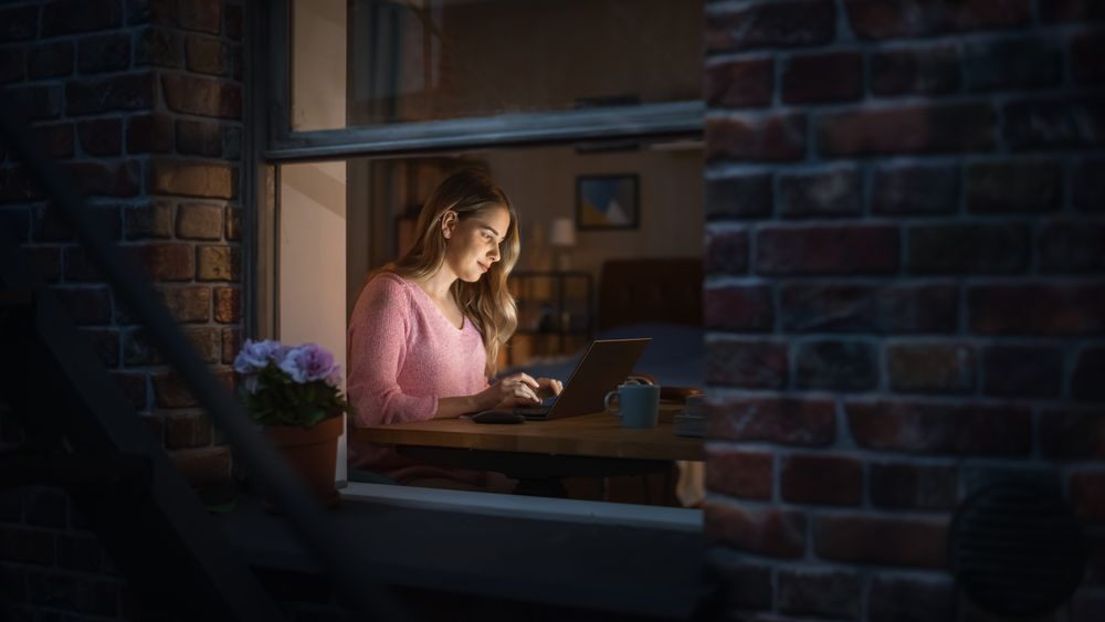 Female Professional Freelancer Working from Cozy Home at Night.