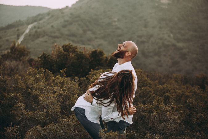 Affectionate couple having fun on hilly valley