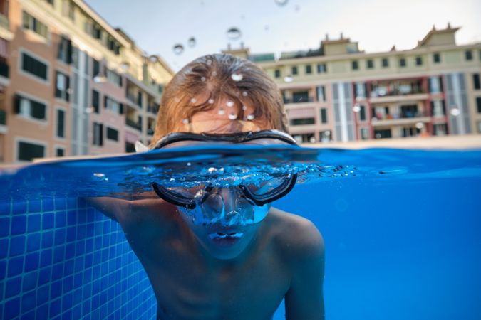 Boy in diving mask swimming in pool in hotel