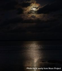 Full moon behind clouds above an ocean 4BrpW4