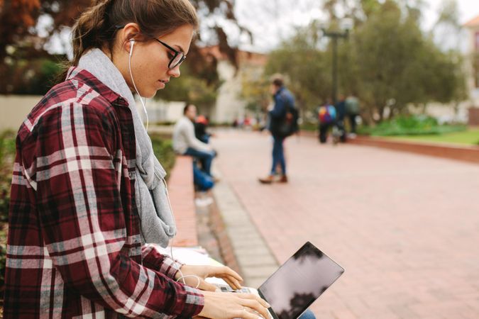 Side view of young university student working on laptop