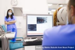 Man checking screen of scan of patient’s eye 0veaGb