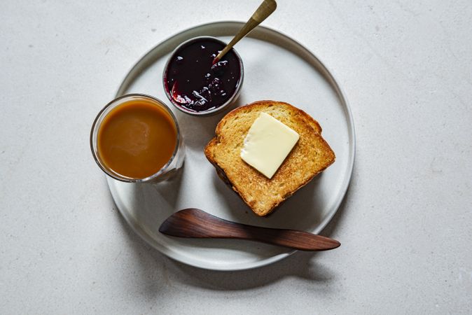 Top view of toast with butter and jam on a plate