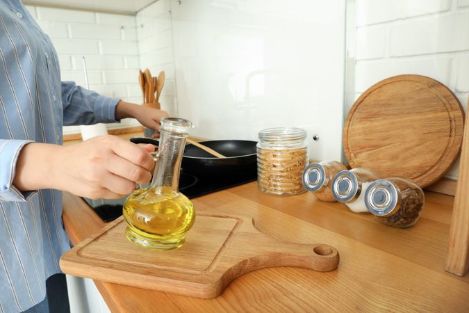 Young woman cooking something in kitchen with modern interior