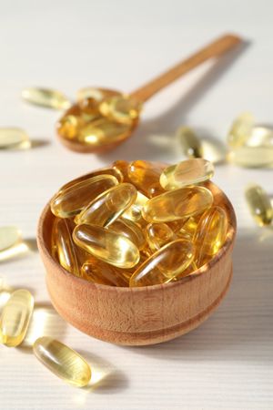 Omega pills in a wooden bowl on a neutral background
