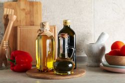 Kitchen table with different supplies and bottles with oil