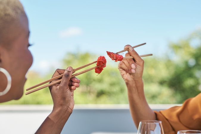 Unrecognizable Black women with tuna sashimi