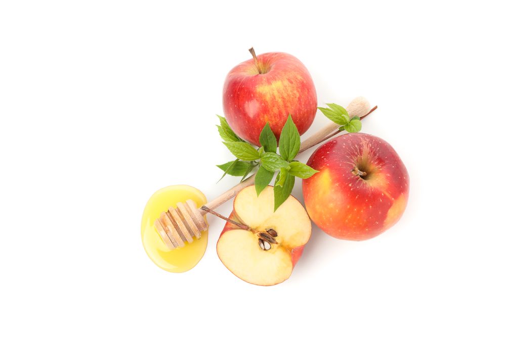 Top view of honey dipper, leaves and apples