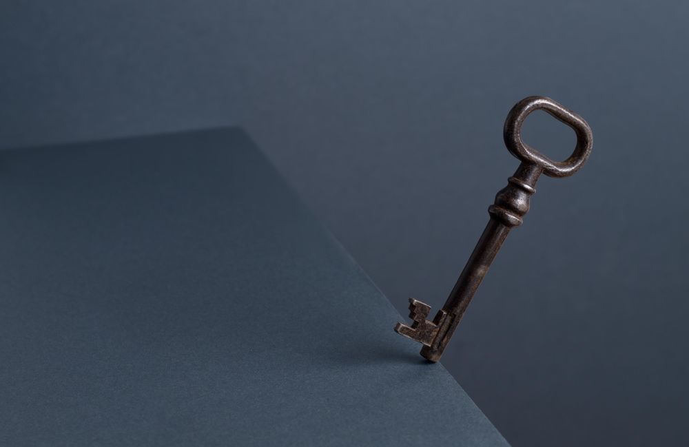 Vintage Key in balance at the edge of the table with dark background