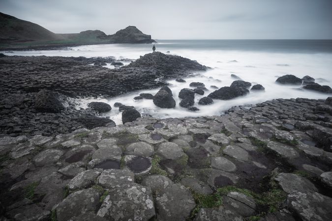 Female standing on cliff and contemplating