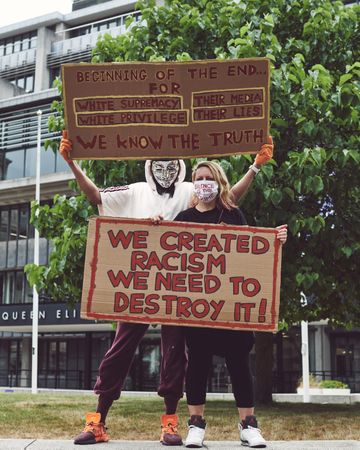 London, England, United Kingdom - June 6th, 2020: Couple holding anti-racism signs