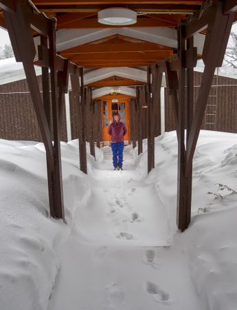 Woman standing in wintry entrance to lodge