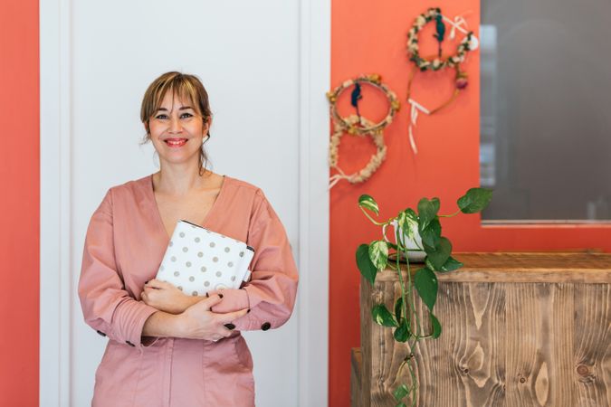 Cheerful cosmetologist looking at camera in spa salon