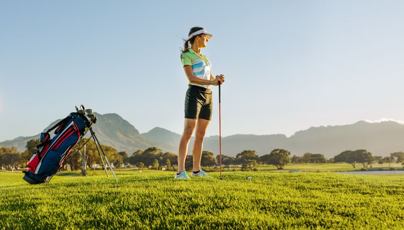 Pro female golfer posing on golf course