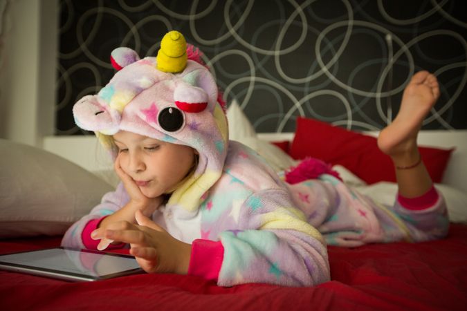 Girl using tablet on bed
