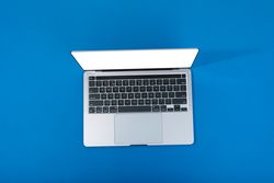 Looking down at blue room with laptop with mockup screen