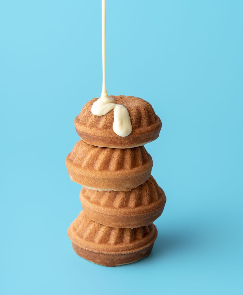 Pouring chocolate topping over mini bundt cakes