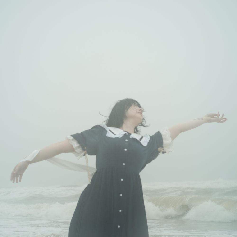 Woman in dark dress dancing on beach